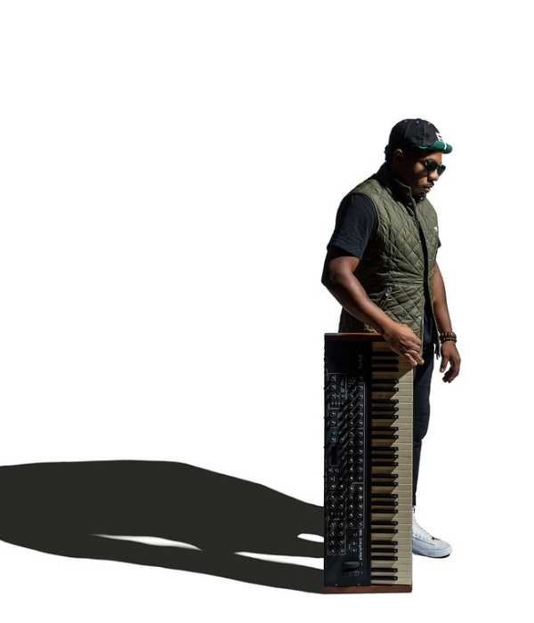 Person in dark clothes holding a keyboard against a stark white background.